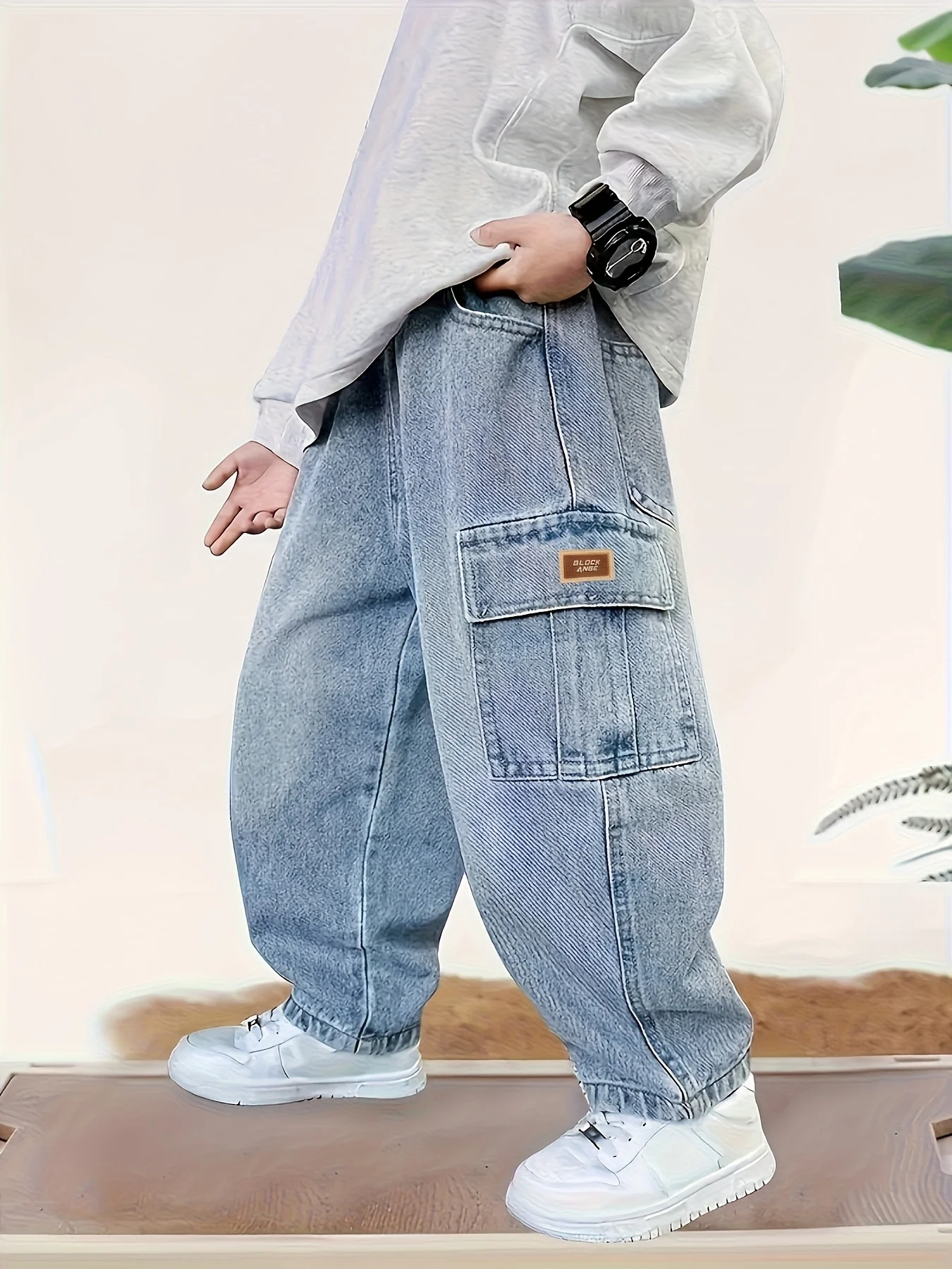 Boy's loose-fit stylish denim work pants with label design, comfortable elasticized waist, and trendy versatile style.